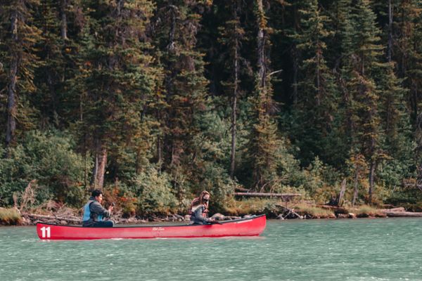 Family canoeing on a Rockies lake with a guide