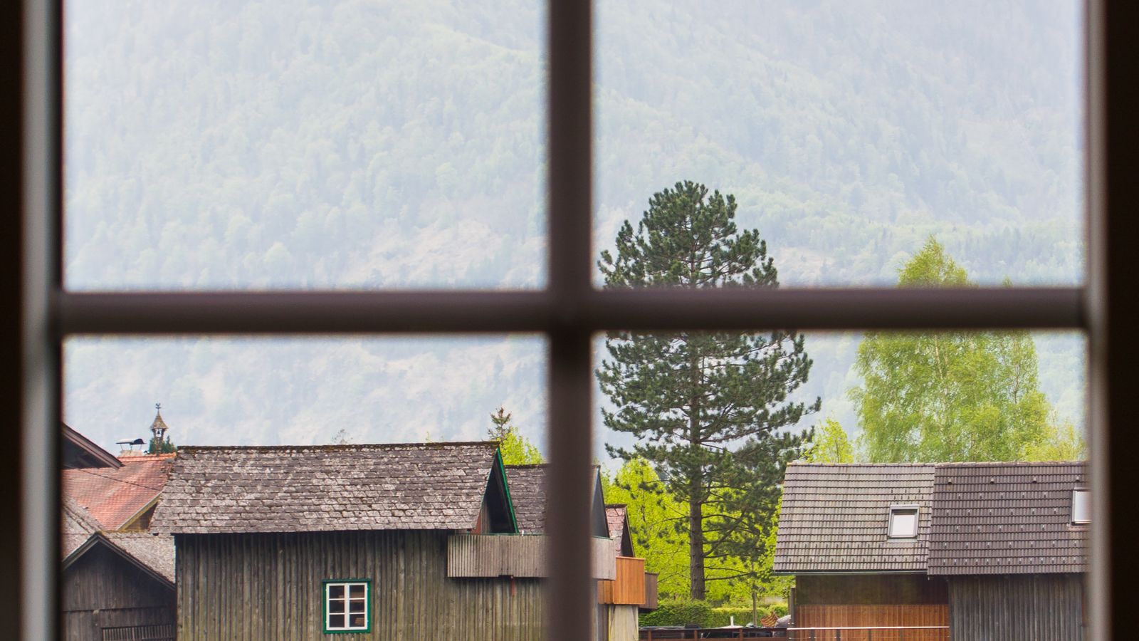 Canada honeymoon luxury: a lodge window looking out over a mountain lake at dusk