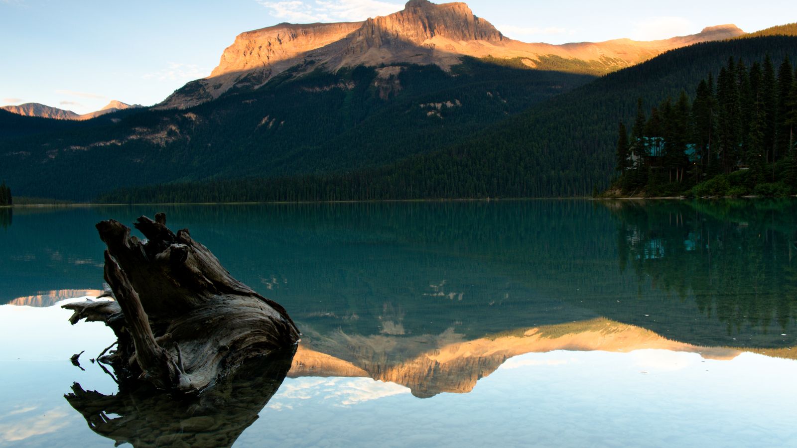 Unhurried evening light over a Canadian mountain lake seen from a lodge