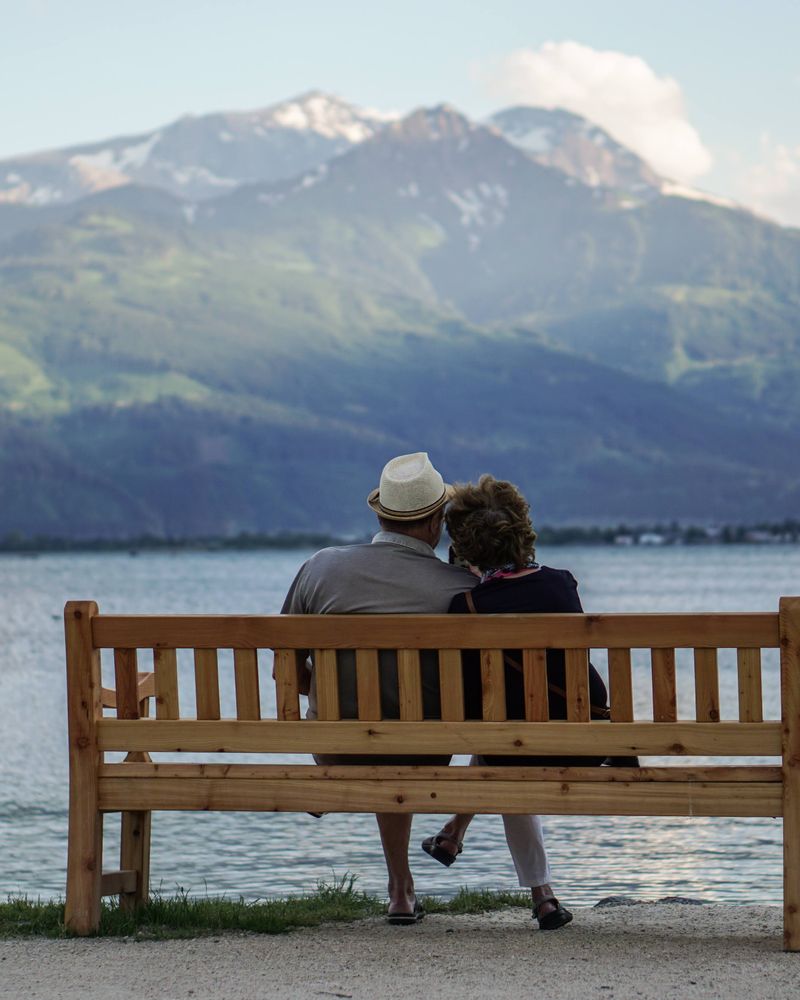 Retired couple on a lodge deck overlooking a Canadian mountain lake
